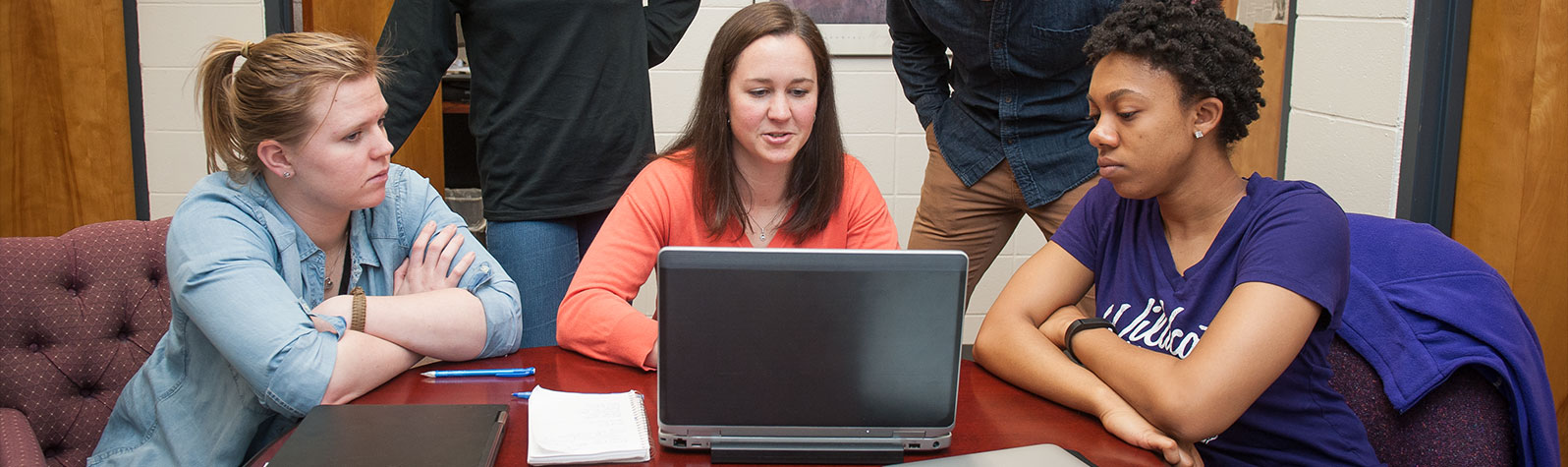 students around a laptop