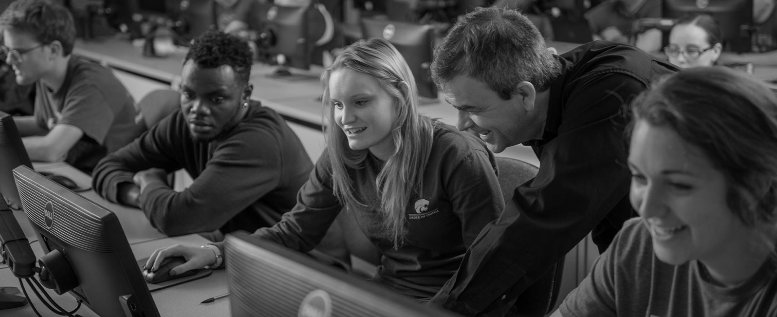 Teacher looking at a computer screen with students