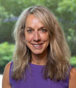 female headshot wearing a purple shirt